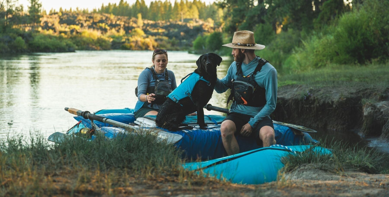 Eddy the lab sits with her humans in their raft.